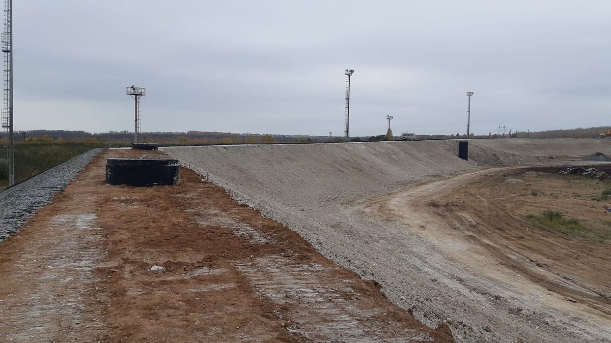 Панорама дамбы: спланированный гребень и укрепленный щебнем откос